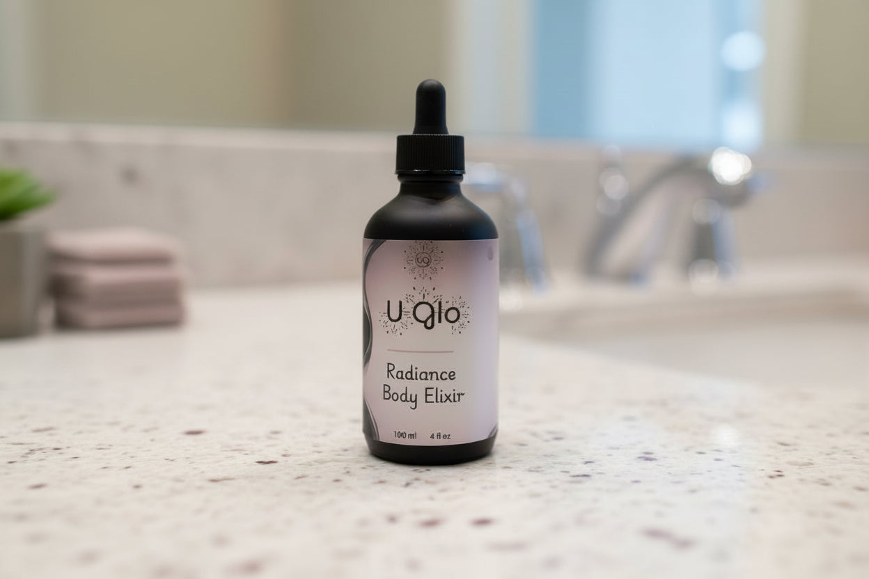 Uqlo Radiance Body Elixir bottle on a textured beige surface