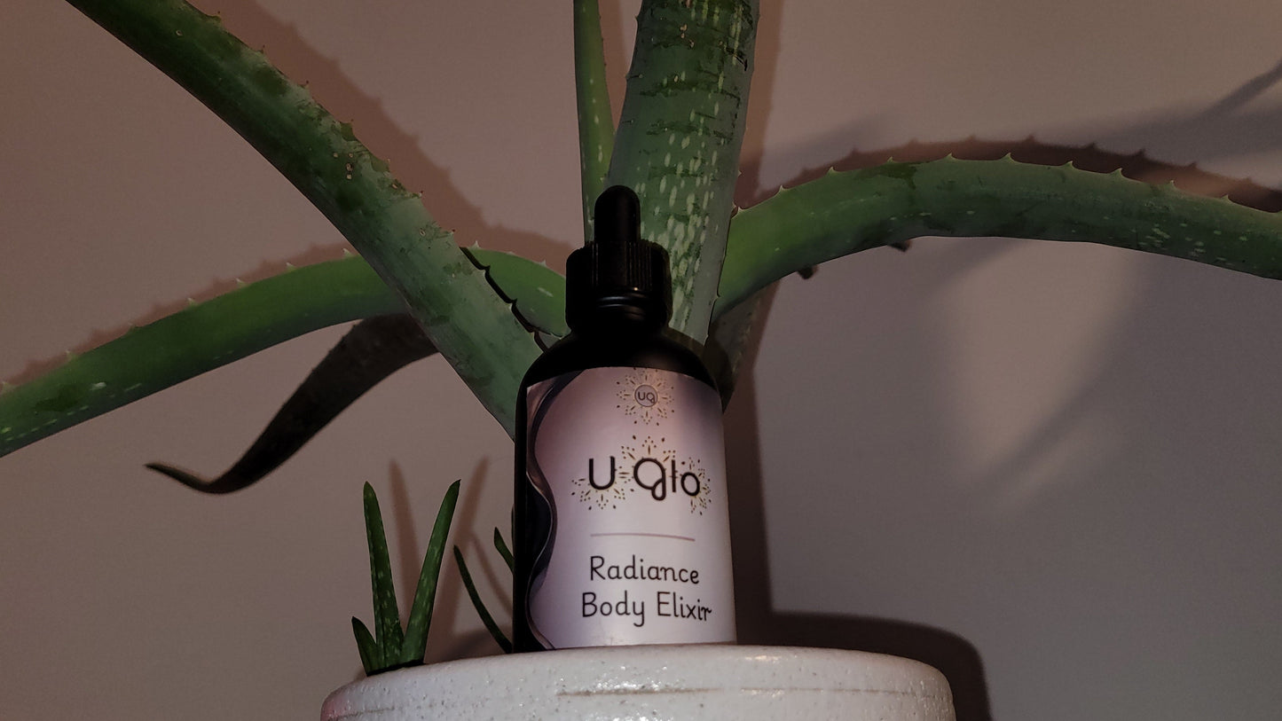 U-Qlo Radiance Body Elixir bottle with dropper against a plant background