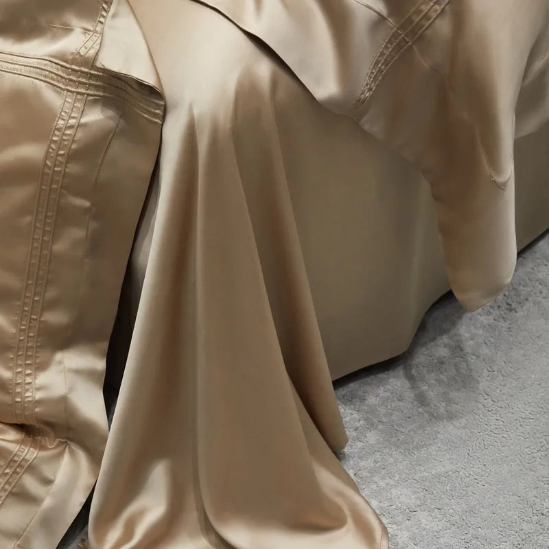 Close-up of a beige bedding corner hanging off bed with light grey surface below